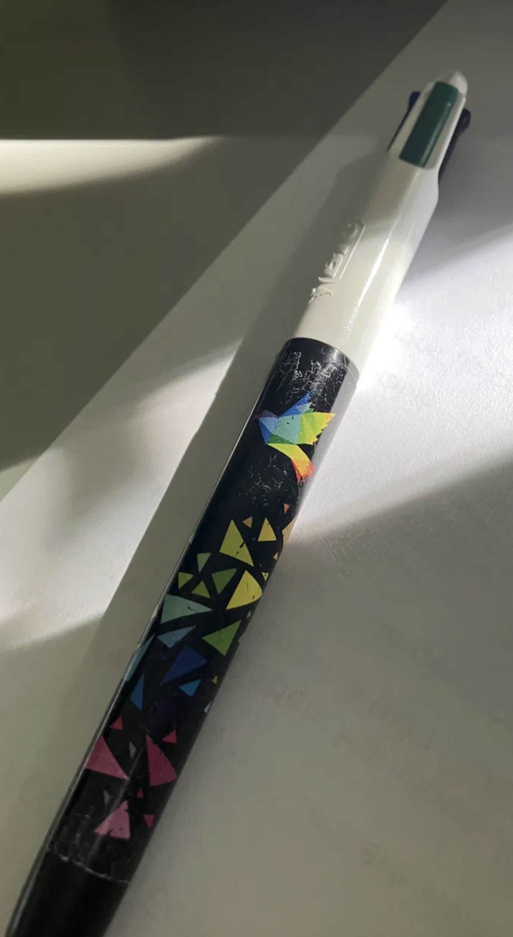 Stylo Bic 4 couleurs avec oiseau origami multicolore, dans un rai de lumière